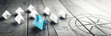 Blue Paper Boat Leading A Fleet Of Small White Boats With Compass Icon On Wooden Table With Vintage Effect - Leadership Concept