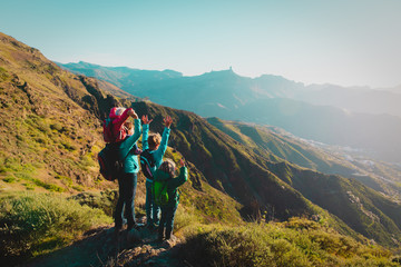 happy mother with kids travel in sunset mountains, family hiking in nature