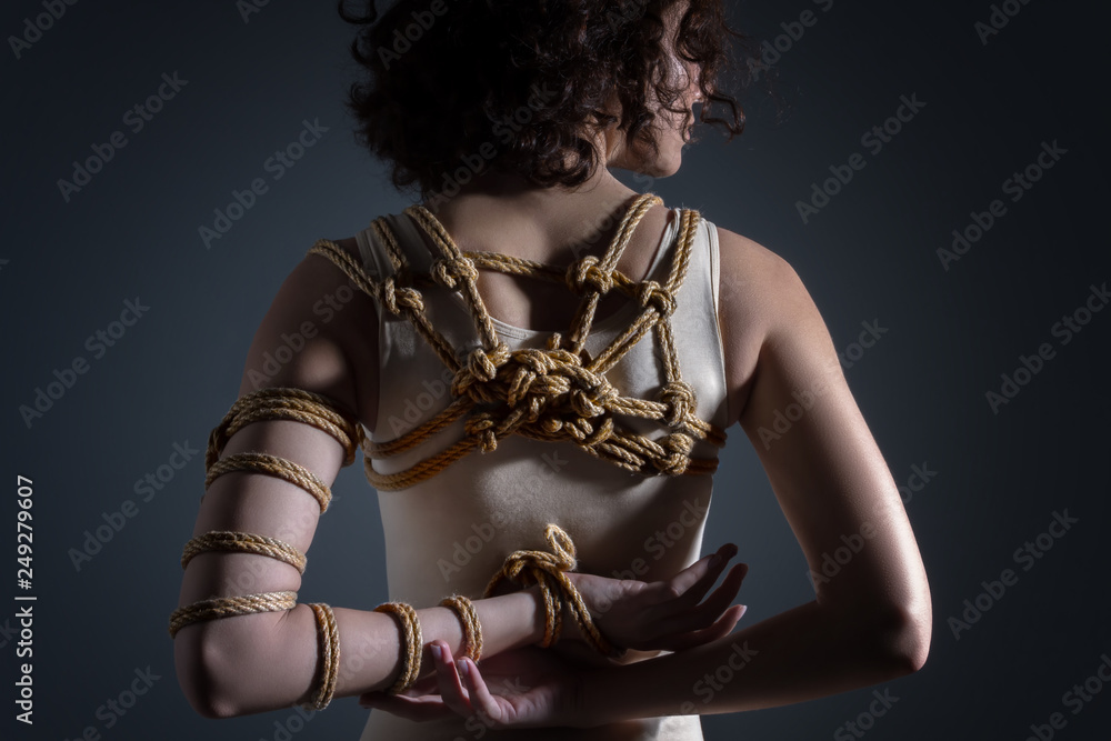 Foto de Stock Young slim woman with strapped hand and back on gray