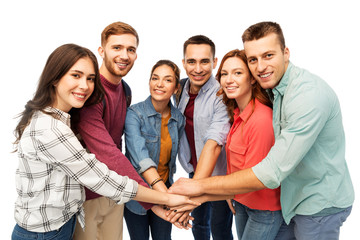 Wall Mural - friendship and people concept - group of smiling friends stacking hands over white background