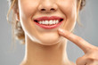 © Syda Productions - oral care, dental hygiene and people concept - close up of finger pointing to woman face with healthy white teeth over gray background