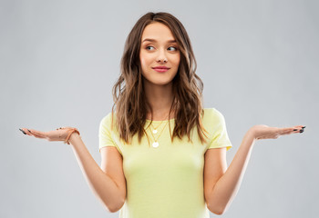 choice and people concept - smiling young woman or teenage girl in blank yellow t-shirt holding some