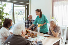 Nurse Serving Meal To Senior People At Home
