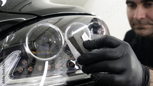 Fotomural Professional ceramics handler apply different layers to the car using an applicator (sponge, fiber) immediately checking the effect