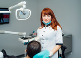 Fototapeta Panele - Young woman at dentist. Dentist is repairing her teeth