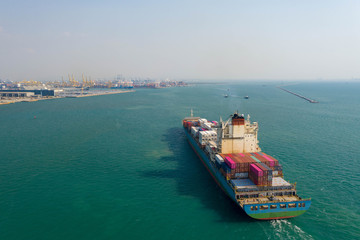 Aerial view. Container ship in pier with crane bridge carries out export and import business in the open sea. Logistics and transportation