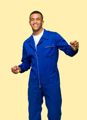 Young afro american worker man enjoy dancing while listening to music at a party on isolated background