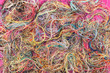 Colorful tangled threads on pink background. Closeup.