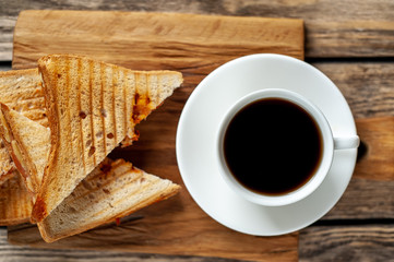 two sandwiches and coffee on a wood background