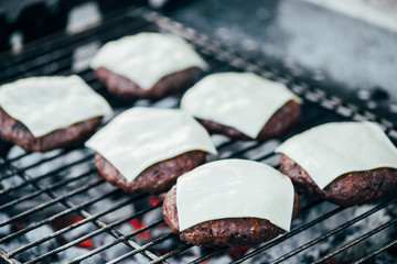 Wall Mural - selective focus of grilled fresh burger cutlets with cheese on bbq grid