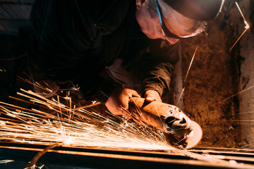 Wall Mural - worker using grinder while working on steel metal railings