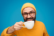© kegfire - Smiling hipster in yellow drinking coffee
