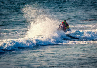 riding a jet ski / wave runner in Goa sea, wearing safety jackets. Baga beach.  water sports famous in summer vacation  in Goa India