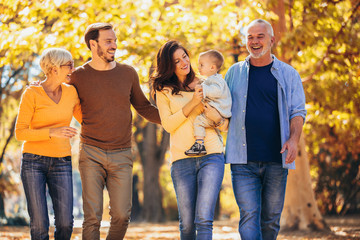 Wall Mural - Multl generation family in autumn park having fun