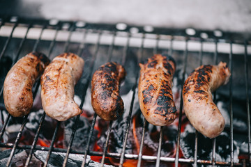 Canvas Print - selective focus of grilled delicious sausages on bbq grid