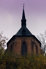 The Christian chapel in Gothic style stands on a hill.Chapel with large decorated stained-glass windows and a pointed roof.