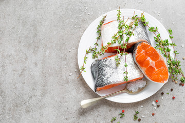 Fresh raw salmon fish steaks on white kitchen background. Top view