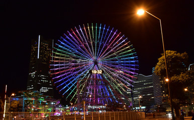 Wall Mural - Night view of the light of the Ferris wheel of the park and the illuminations of the street