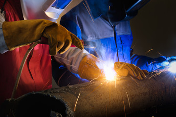 Wall Mural - Welding skills training of welder with protective mask and welding steel metal part.