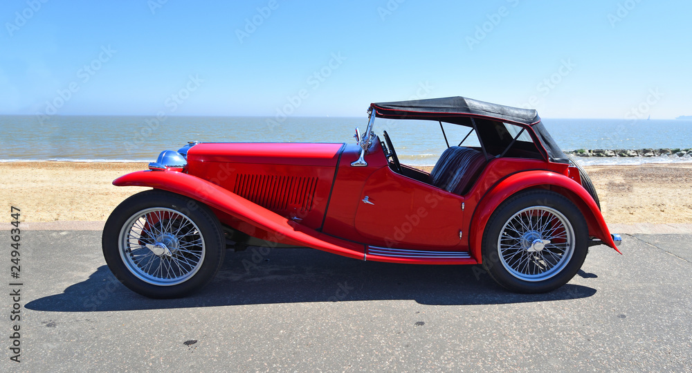 Classic Red Sports Car parked on Seafront  Promenade. - obrazy, fototapety, plakaty 