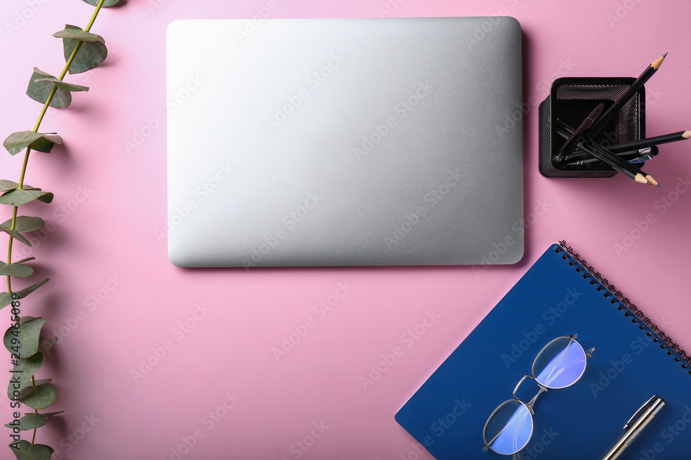 Stylish workplace with laptop and stationery on color background