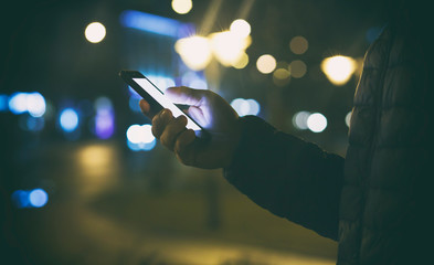 The young guy is using his phone in the street