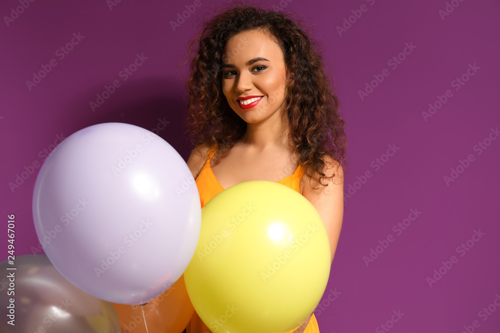 Beautiful young woman with balloons on color background