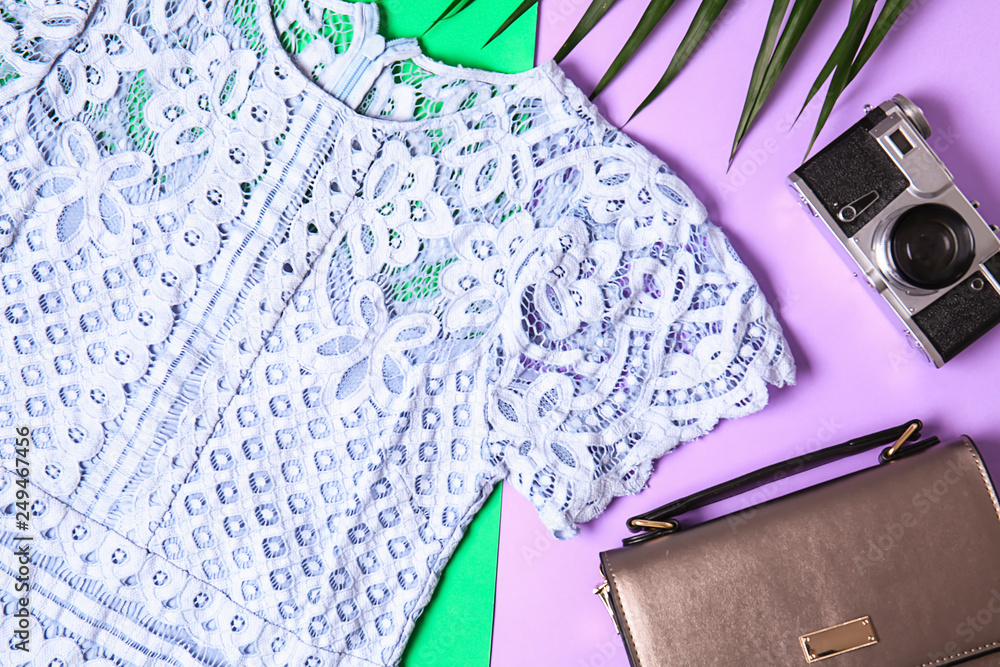 Summer composition with female clothes, bag and photo camera on color background