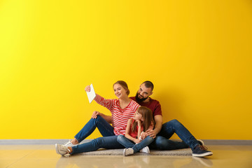 Sticker - Happy family taking selfie while sitting on floor in their new flat