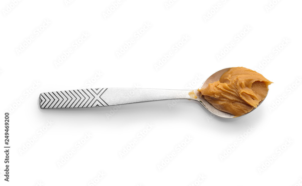 Spoon with tasty peanut butter on white background