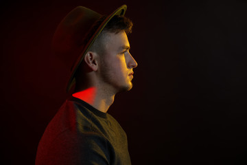 Toned portrait of handsome young man on dark background