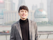 © atiger - Portrait of a handsome Chinese young man in casual suit smiling and looking at camera confidently with Shanghai bund background, winter fashion, cool young man lifestyle.