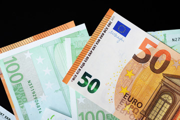 One Hundred and Fifty euro banknotes on a dark background close up