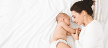 Young Mom And Her Cute Baby Sleeping In Bed