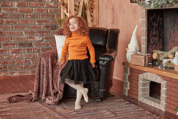 little girl standing by the fireplace and pointing at you