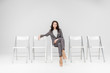 © LIGHTFIELD STUDIOS - attractive woman sitting with crossed legs on chair isolated on grey