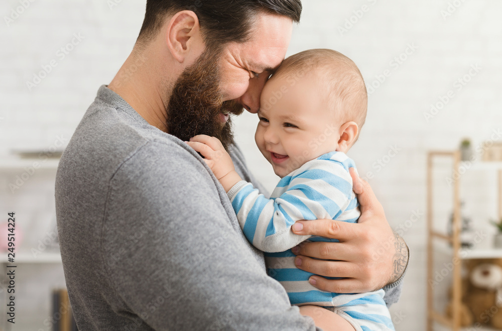 Loving father embracing his cute baby son - obrazy, fototapety, plakaty 