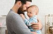 © Prostock-studio - Loving father embracing his cute baby son