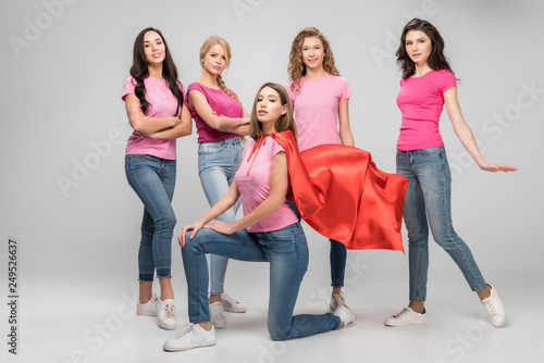 Cuadros en Lienzo confident girl wearing red superhero cape near attractive women on grey backgrou