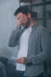 © LIGHTFIELD STUDIOS - depressed man covering face with hand, holding photograph and crying through window with raindrops