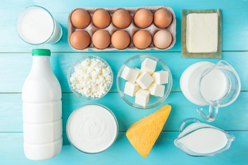 Dairy products. Milk, kefir, cottage cheese, cheese, sour cream, butter, cream and eggs on blue wooden background