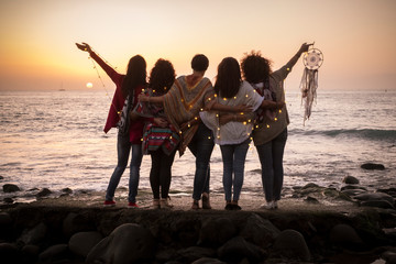 dreaming image with group of females friends hug each other all together looking the sunset for frie