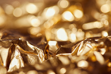 selrctive focus of golden foil with bright sparkling lights