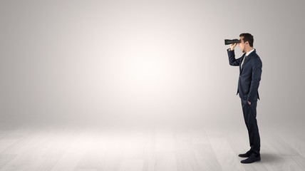 Wall Mural - businessman looking forward with binoculars in an empty space