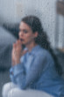 © LIGHTFIELD STUDIOS - selective focus of raindrops on windows with sad woman sitting and praying on background