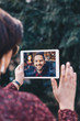 © mlasaimages - Young woman using a tablet by having a video call chat with her businessman boyfriend who is away on a business trip. Concept of keeping a long distant relationship in a career oriented world.