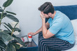 © LIGHTFIELD STUDIOS - man photo holding funeral urn, covering face with hand and grieving near photo frame with picture of woman and wedding rings