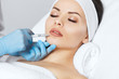 © Dimid - The doctor cosmetologist makes Lip augmentation procedure of a beautiful woman in a beauty salon.Cosmetology skin care.
