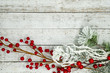 © MelissaMN - White flocked branches, twigs and berries, isolated on white wood background. Useful for Christmas and winter holiday backgrounds, messages and banners