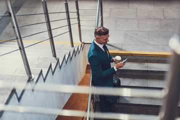 Wall Mural - Man looking at telephone screen on stairs